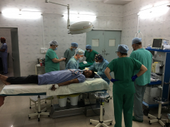 Operace ruky v místním umrtvení, asistuje a pomáhá místní muž, který se narodil ve slumu a nyní pracuje jako sálová sestra.